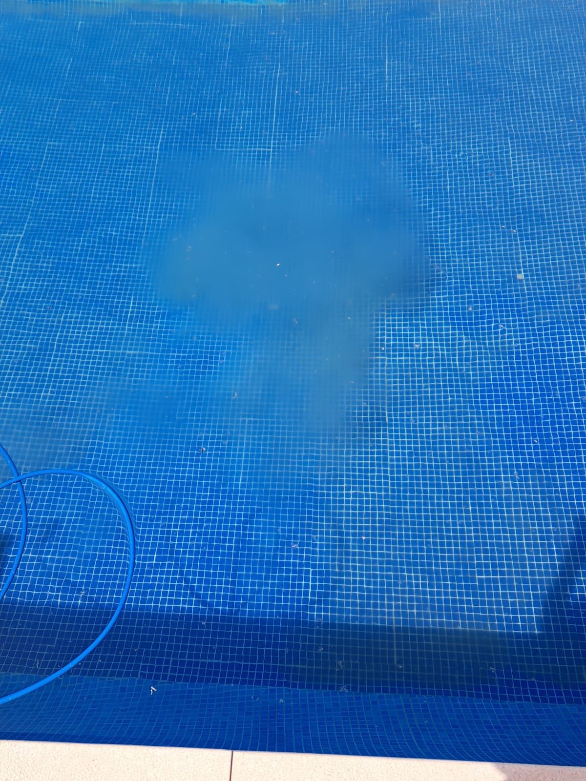 Limpiafondos de piscina haciendo efecto chimenea en un suelo con floculos.